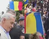 Un susținător de-ai lui Călin Georgescu a fost săltat de jandarmi la IPJ Ilfov după ce a afișat un steag legionar, interzis de lege. În urmă cu două săptămâni, un alt simpatizant a fost ridicat după ce a înjurat forțele de ordine și s-a îmbrâncit cu manifestanții