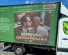 Camion cu o poză AI în care Ilie Bolojan și Dominic Fritz se sărută, parcat în fața guvernului. Mesaje împotriva premierului: „Împreună vindem România”