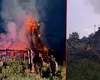 O biserică de lemn veche, cuprinsă de flăcări. Turla de 25 de metri riscă să se prăbușească