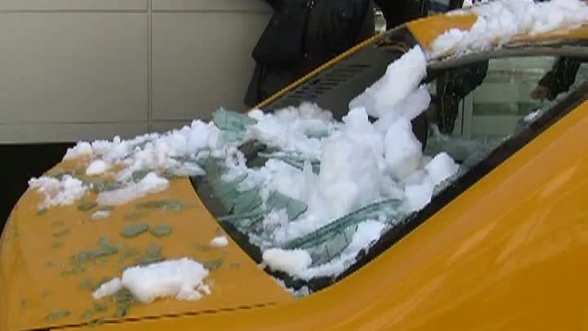 Maşini avariate de bucăţi de gheaţă desprinse de pe acoperişurile unor clădiri
