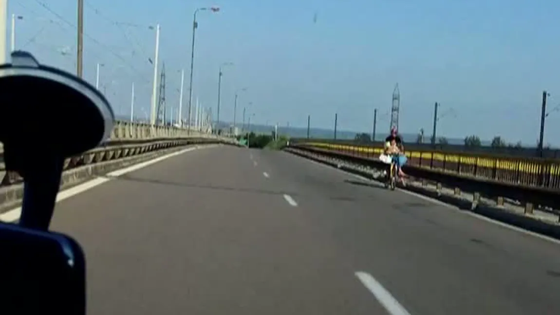 PĂRINŢI INCONŞTIENŢI: Surprinşi cu bicicleta pe autostradă şi cu bebeluşul în braţe VIDEO