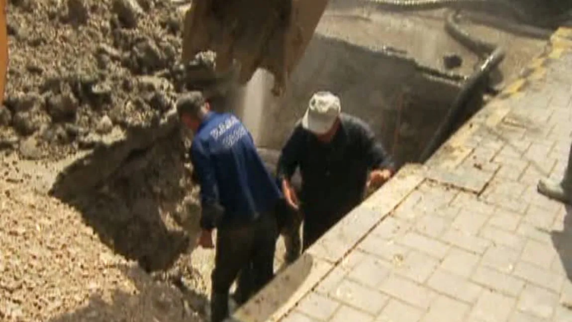 Treabă românească: Muncitorii încearcă să repare o ţeavă cu fierăstrăul, fără să oprească apa VIDEO
