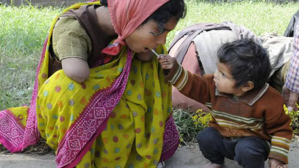 EMOŢIONANT: O fetiţă de doi ani îşi hrăneşte mama care are ambele mâinile amputate FOTO