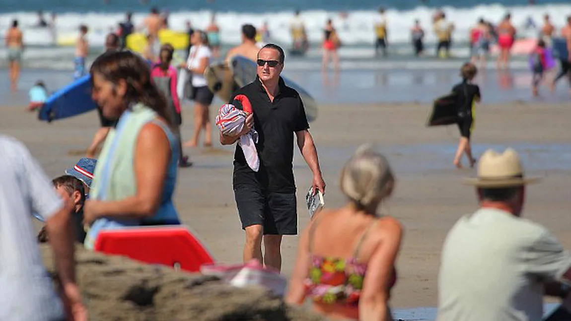 Premierul Marii Britanii, ars de soare pe plajă. Imagini cu David Cameron la bustul gol
