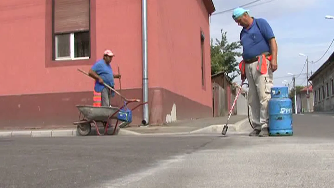 Lucrări de mântuială la reabilitarea străzilor din Mehedinţi. Muncitorii repară fisurile din asfalt cu butelia