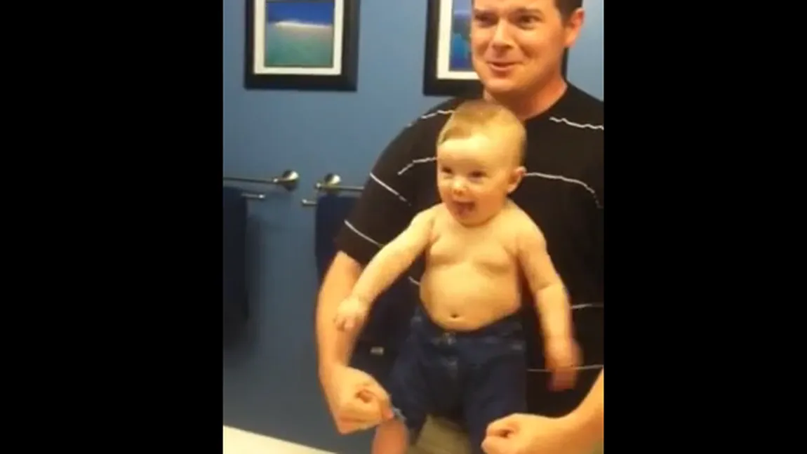 MORI DE RÂS. Un bebeluş ADORABIL îşi imită tatăl care-şi încordează muşchii în oglindă VIDEO