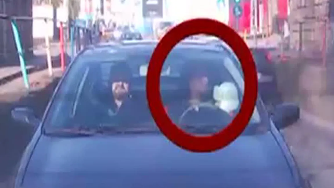Inconştienţa nu are limite. O mamă, filmată când conduce cu copilul în braţe VIDEO