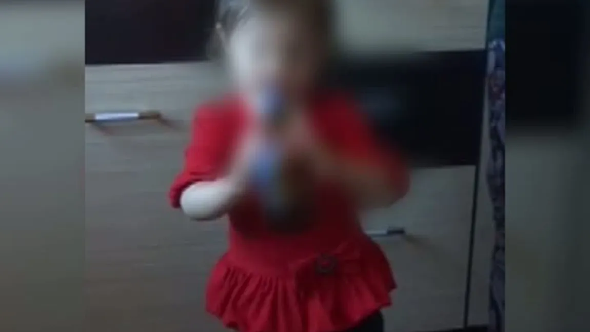 O fetiţă de doi ani, învăţată de părinţi să bea alcool VIDEO