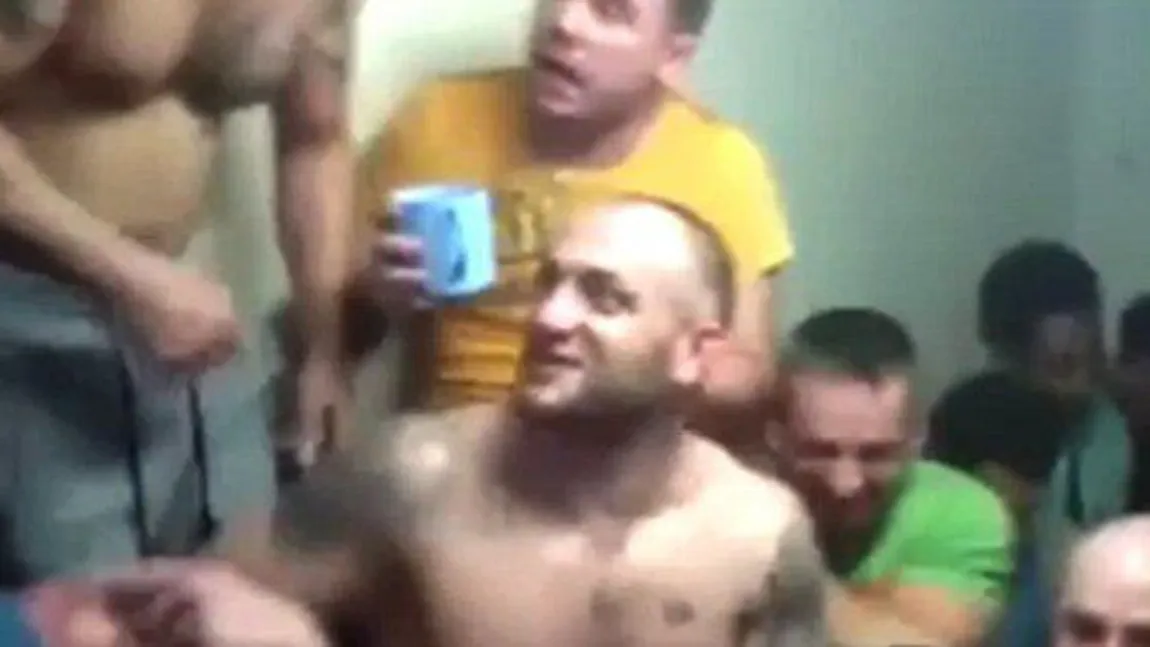 Petrecere cu INTERLOPI în puşcărie. Infractorii flutură telefoanele mobile şi beau alcool VIDEO