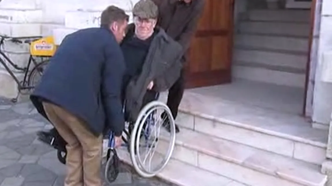 REVOLTĂTOR. Un bătrân în scaun cu rotile, ajutat de trecători să intre în Tribunalul Bacău VIDEO