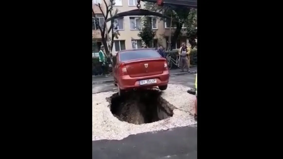 Maşină căzută într-o groapă după ce asfaltul de sub ea s-a surpat
