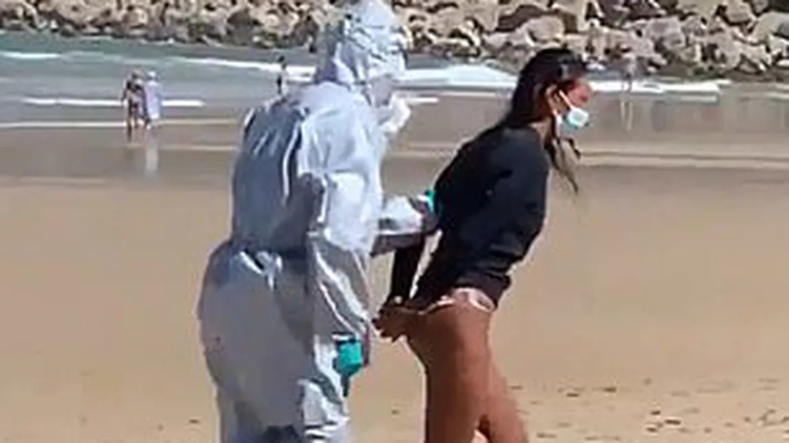 Imagini incredibile pe o plajă din Spania. O femeie care făcea surf a fost arestată din cauză că a intrat în mare infectată cu Covid