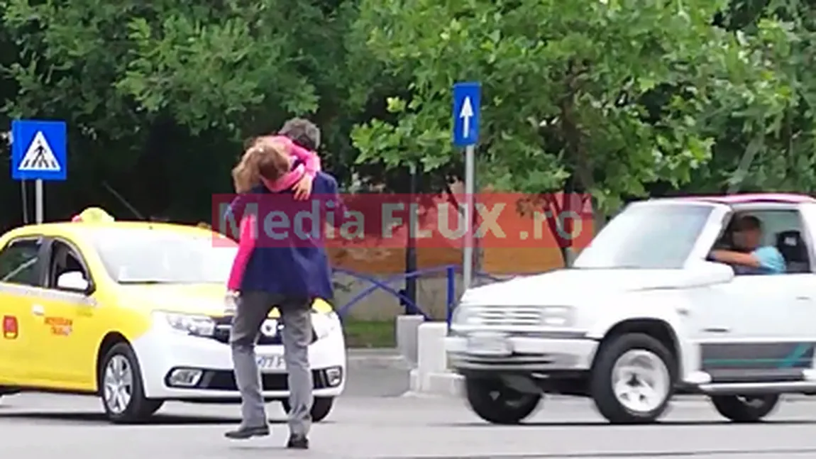 VIDEO. Imagini incredibile: Nicușor Dan traversează un bulevard cu 4 benzi cu fetița în brațe. Iresponsabil până la capăt, vorbește și la telefon