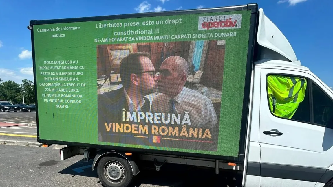 Camion cu o poză AI în care Ilie Bolojan și Dominic Fritz se sărută, parcat în fața guvernului. Mesaje împotriva premierului: „Împreună vindem România”