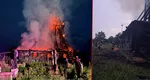 O biserică de lemn veche, cuprinsă de flăcări. Turla de 25 de metri riscă să se prăbușească
