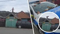 Un bărbat urcat pe acoperiș a atacat cu țigle polițiștii veniți să-l dea jos. Le-a spus că nu coboară până nu îi pun o manea