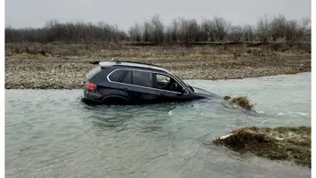 Un BMW X5 a ajuns în râu. Șoferul beat și fără permis și-a abandonat bolidul în apă
