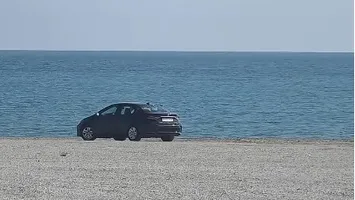 Mașină înmatriculată în Bucureşti, filmată pe plajă, la Cap Aurora. Mesaj ironic la adresa şoferului: „«Sânt ân faţă pe avari»
