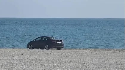 Mașină înmatriculată în Bucureşti, filmată pe plajă, la Cap Aurora. Mesaj ironic la adresa şoferului: „«Sânt ân faţă pe avari»
