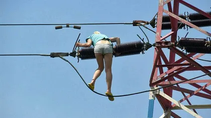 O femeie sub influenţa drogurilor s-a urcat pe un stâlp de electricitate de 10 metri FOTO