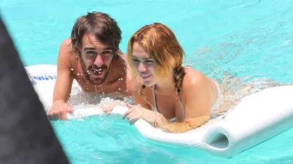 Miley Cyrus flirtează cu un tânăr la piscină, deşi de abia s-a logodit FOTO