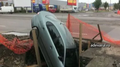 Maşină înghiţită de groapa din asfalt VIDEO