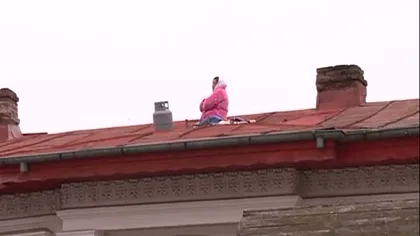 PROTEST EXTREM în Capitală: O femeie s-a urcat pe acoperiş cu o butelie şi ameninţă că îşi dă foc