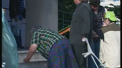 Bătrână cu handicap, obligată să se TÂRASCĂ pe scări pentru o ştampilă VIDEO