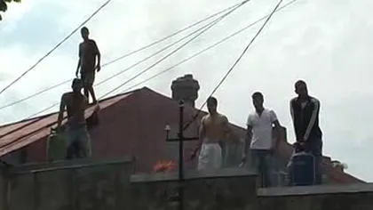 Patru adulţi şi doi copii s-au urcat pe un acoperiş şi au ameninţat că-şi dau foc VIDEO