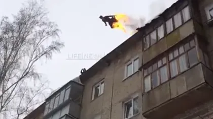CASCADORIE EXTREMĂ. Un rus în flăcări sare de la etajul 4 pe un maldăr de zăpadă VIDEO