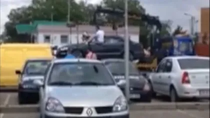 SCANDAL într-o parcare din Timişoara: O maşină, ridicată de hingheri, cu tot cu şoferită VIDEO