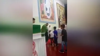 Metoda barbară de a binecuvânta. Un preot este filmat în timp ce loveşte copiii în faţa altarului