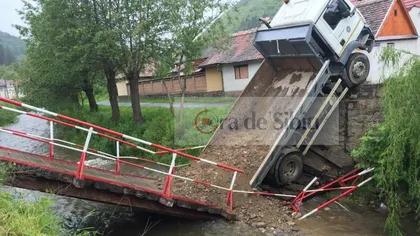 Pod prăbuşit, camion suspendat deasupra râului