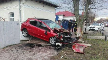 Accident spectaculos în Olt. Cum a ajuns un şofer cu maşina suspendată între o casă şi un copac