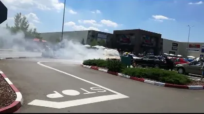 Maşină în flăcări în parcarea unui mall