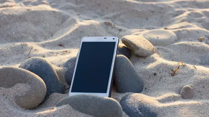 Telefonul mobil se poate strica la mare. Iată cum îl protejezi de nisip, apă, soare şi vânt
