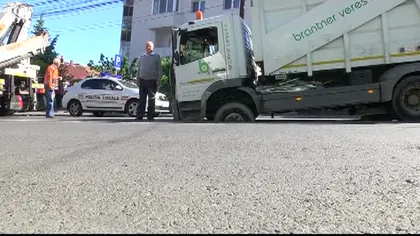 Maşină de gunoi, înghiţită de asfalt VIDEO