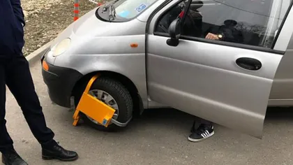 Paznicii unui supermarket din Capitală i-au blocat roata de la maşina unui bătrân cu handicap locomotor