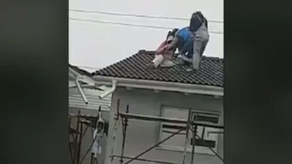 Trei muncitori beţi au fost filmaţi pe acoperişul unui bloc în timp ce încercau să coboare VIDEO