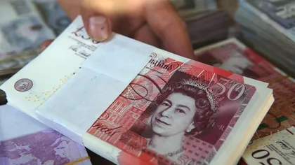 O româncă din Anglia s-a pozat într-un pat plin cu bani. Banda ei a spart nu mai puţin de 400 de case