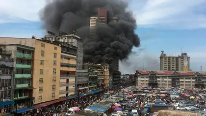 Incendiu devastator într-o clădire cu 5 etaje. Oamenii îşi aruncă bunurile în stradă şi încearcă să stingă focul cu găleţi