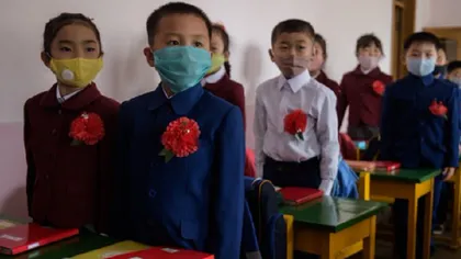 Elevii nord-coreeni s-au reîntors la şcoală. Cu flori roşii în piept şi măşti de protecţie, au fost aşezaţi în bănci unii lângă alţii