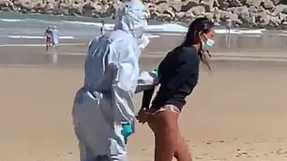 Imagini incredibile pe o plajă din Spania. O femeie care făcea surf a fost arestată din cauză că a intrat în mare infectată cu Covid