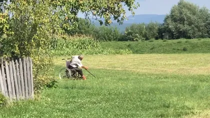 Cea mai valoroasă lecţie de voinţă şi ambiţie! Un bătrân dă cu coasa din scaunul rulant VIDEO