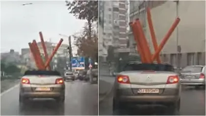 Imagini virale. Craiovean, filmat în timp ce transporta cu o mașină decapotabilă mai multe țevi, pe ploaie VIDEO