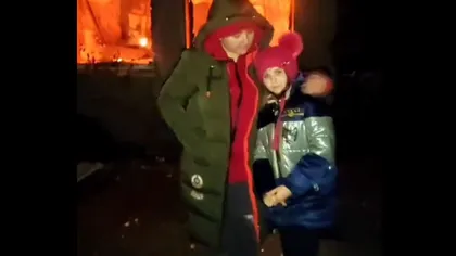 Imagini sfâşietoare! O mamă şi fiica ei din Ucraina stau în faţa propriei case bombardate de ruşi. 