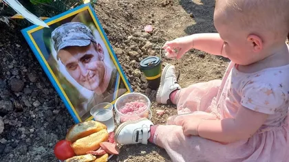 Scene sfâşietoare. O fetiţă din Ucraina îşi petrece ziua de naştere la mormântul tatălui său, decedat  în război