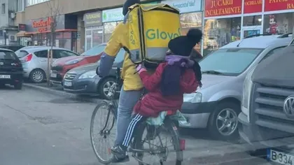 Fotografia virală cu un curier Glovo! Bărbatul își duce copilul la școală în timp ce transportă mâncare pe bicicletă: 