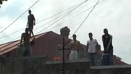 Patru adulţi şi doi copii s-au urcat pe un acoperiş şi au ameninţat că-şi dau foc VIDEO