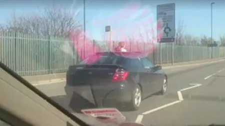 Moment ŞOCANT surprins pe o şosea. O fetiţă de câţiva ani a ieşit pe trapa unei maşini VIDEO